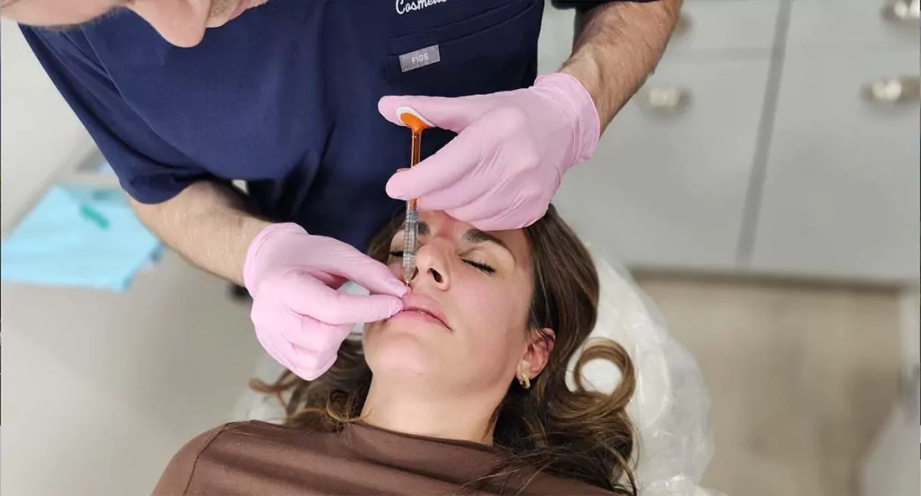 Dr. Schwarzburg administering lip filler injection in New York